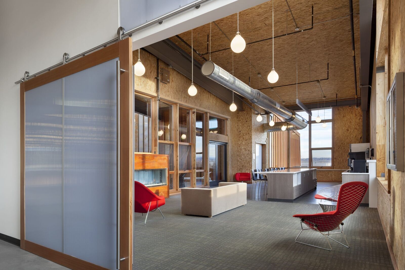 large breakroom with chairs, couch, and kitchen area