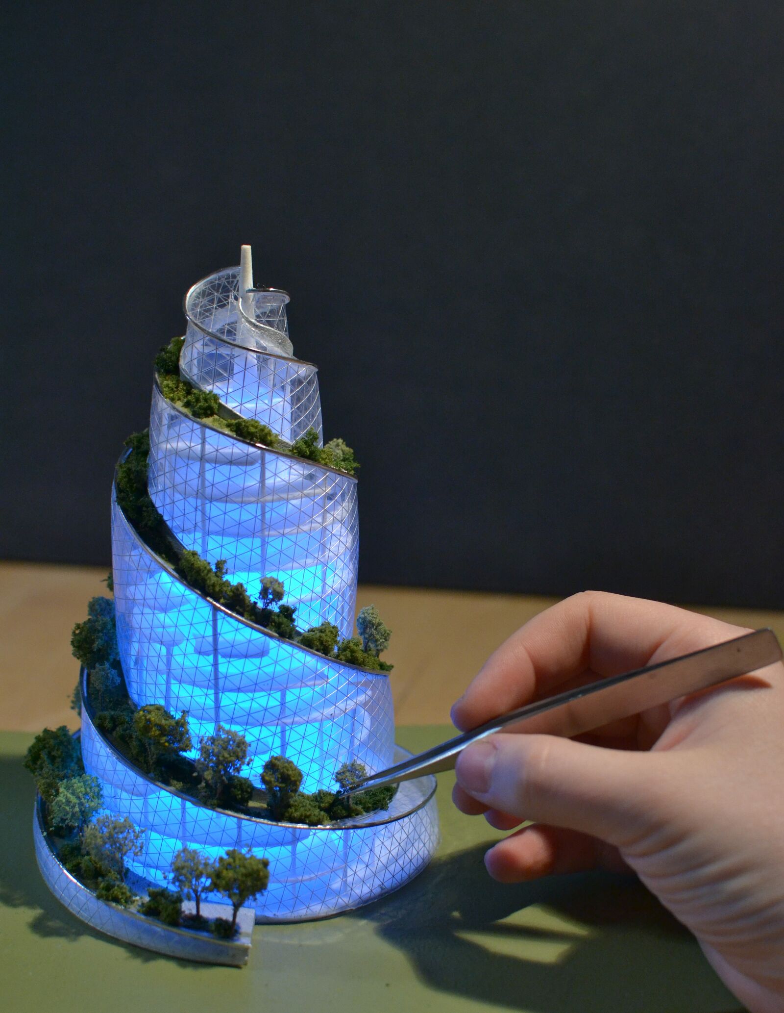 Close up of hand working on helix structure. 