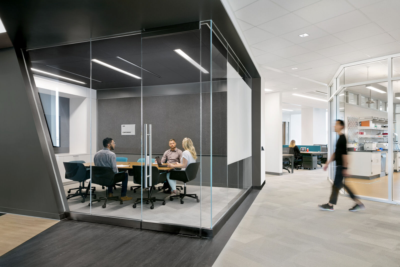 Interior office conference room with people sitting around table