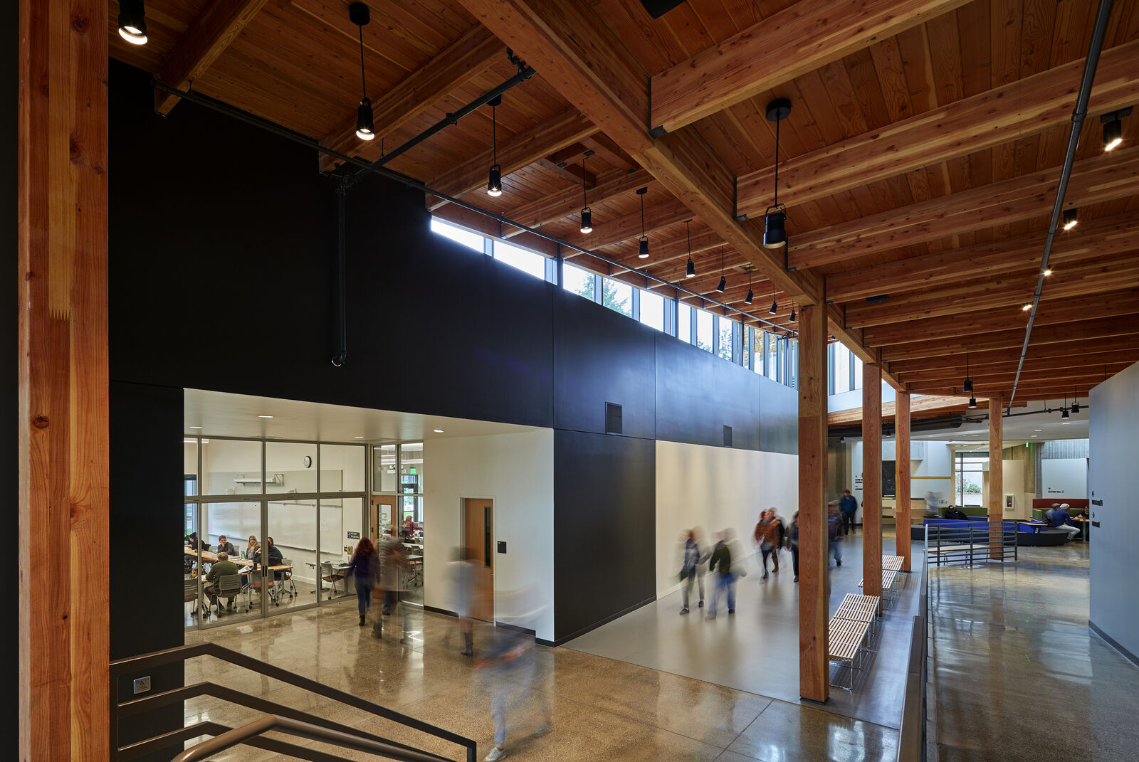 Interior photo of Purce Lecture Hall corridor leading to a classroom with students walking around and heavy timber ceilings