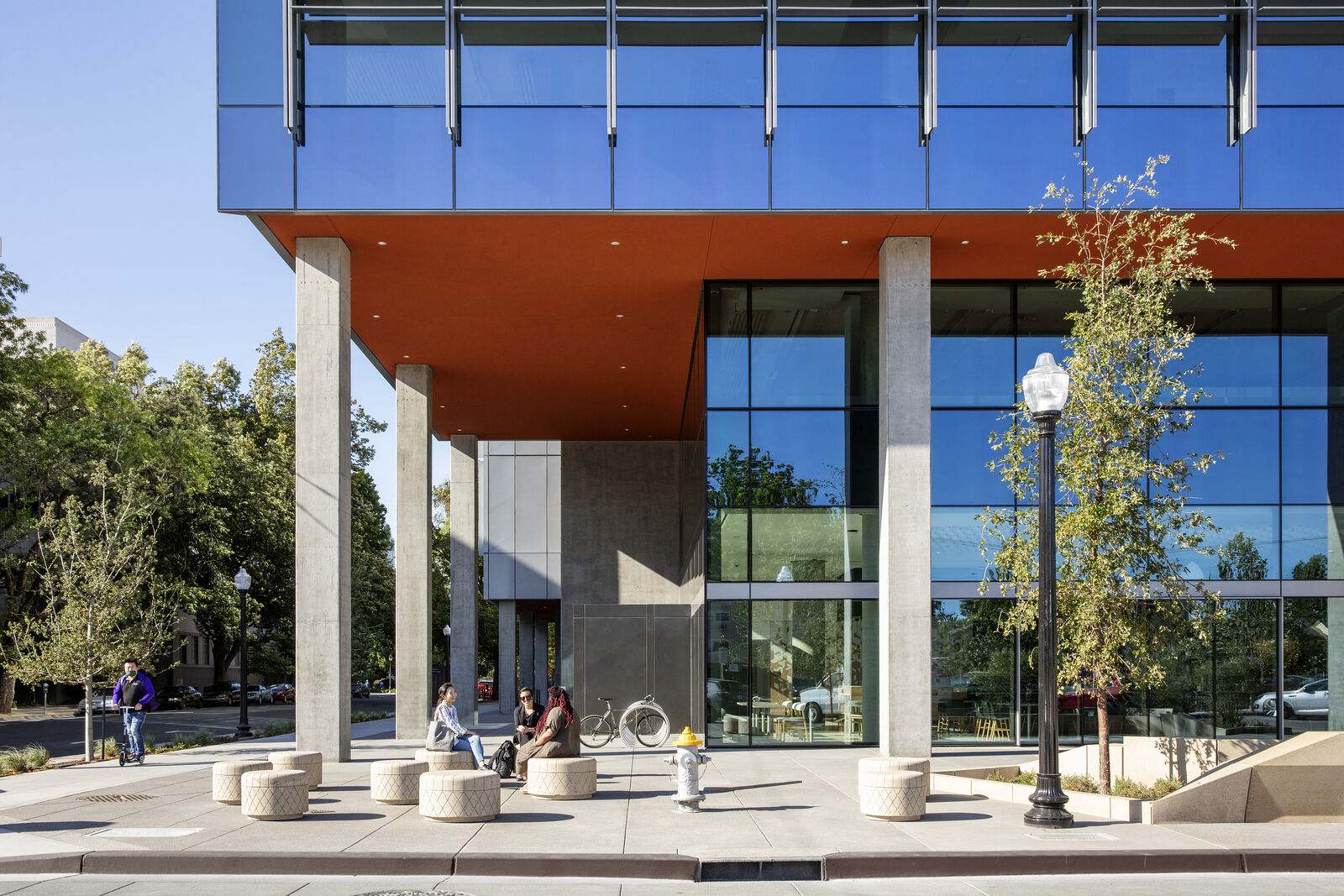 People sitting together outside the entrance to the Clifford L. Allenby Building 
