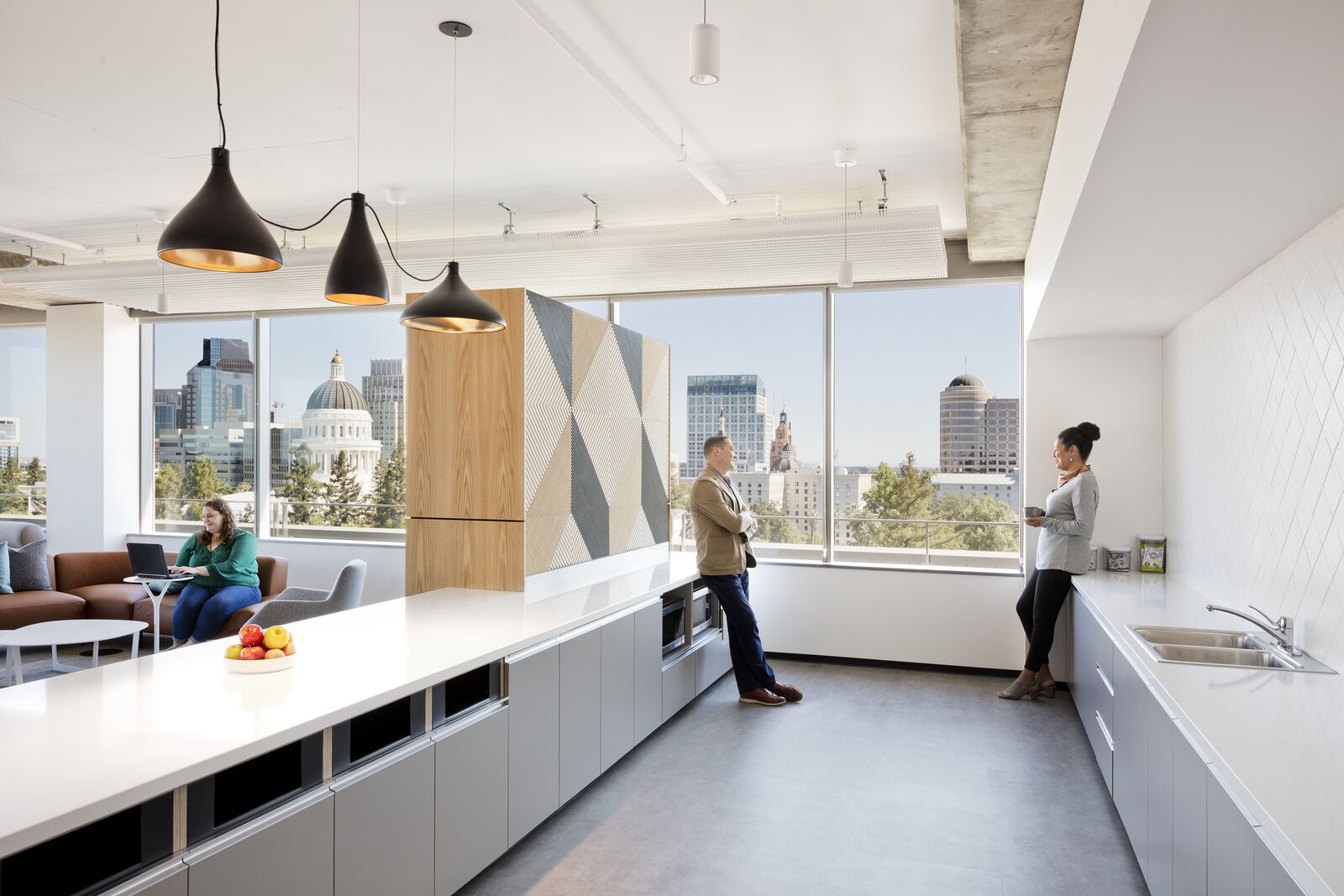 break room area with people leaning against counter space
