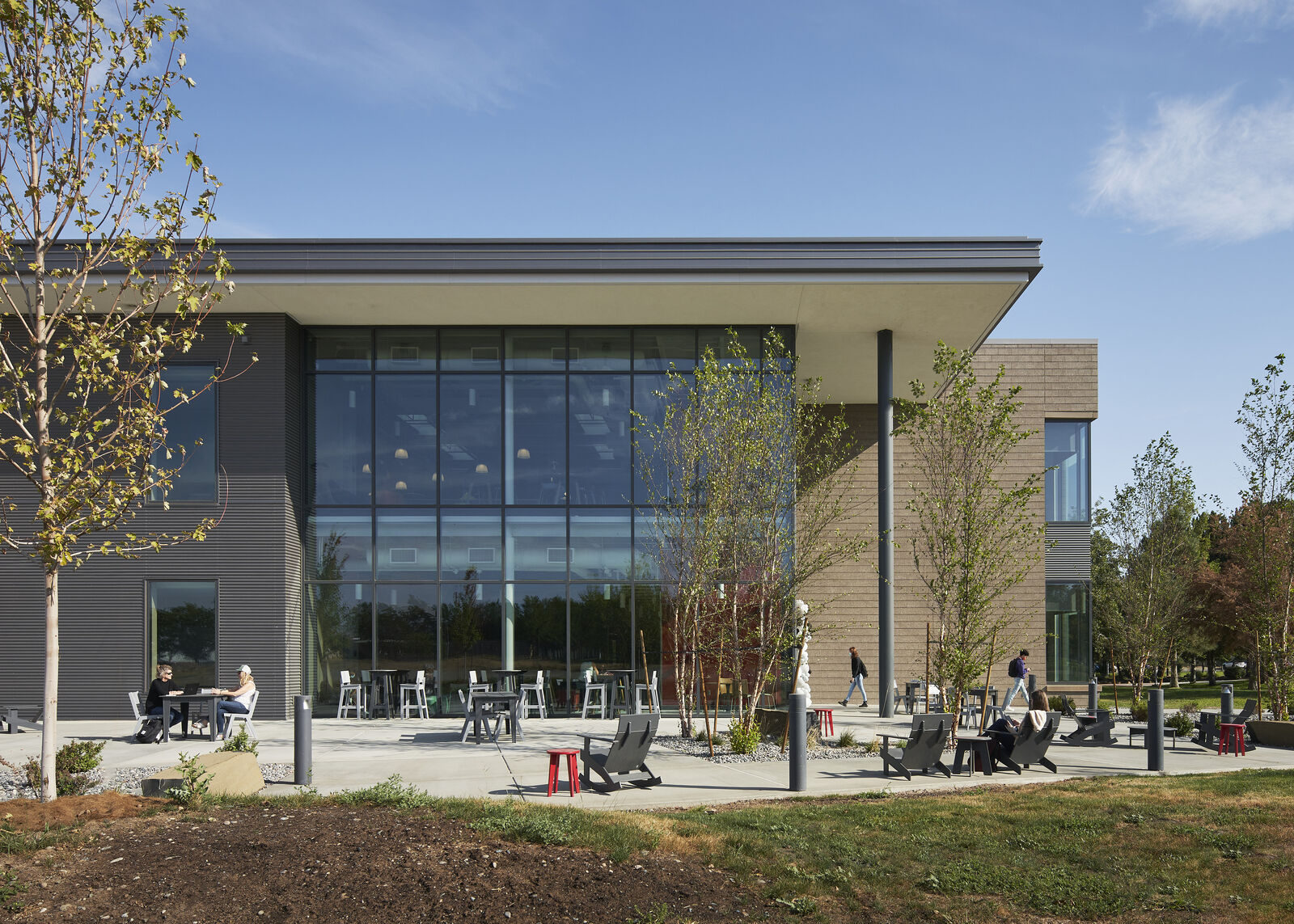 exterior view of building with outdoor furniture and trees 