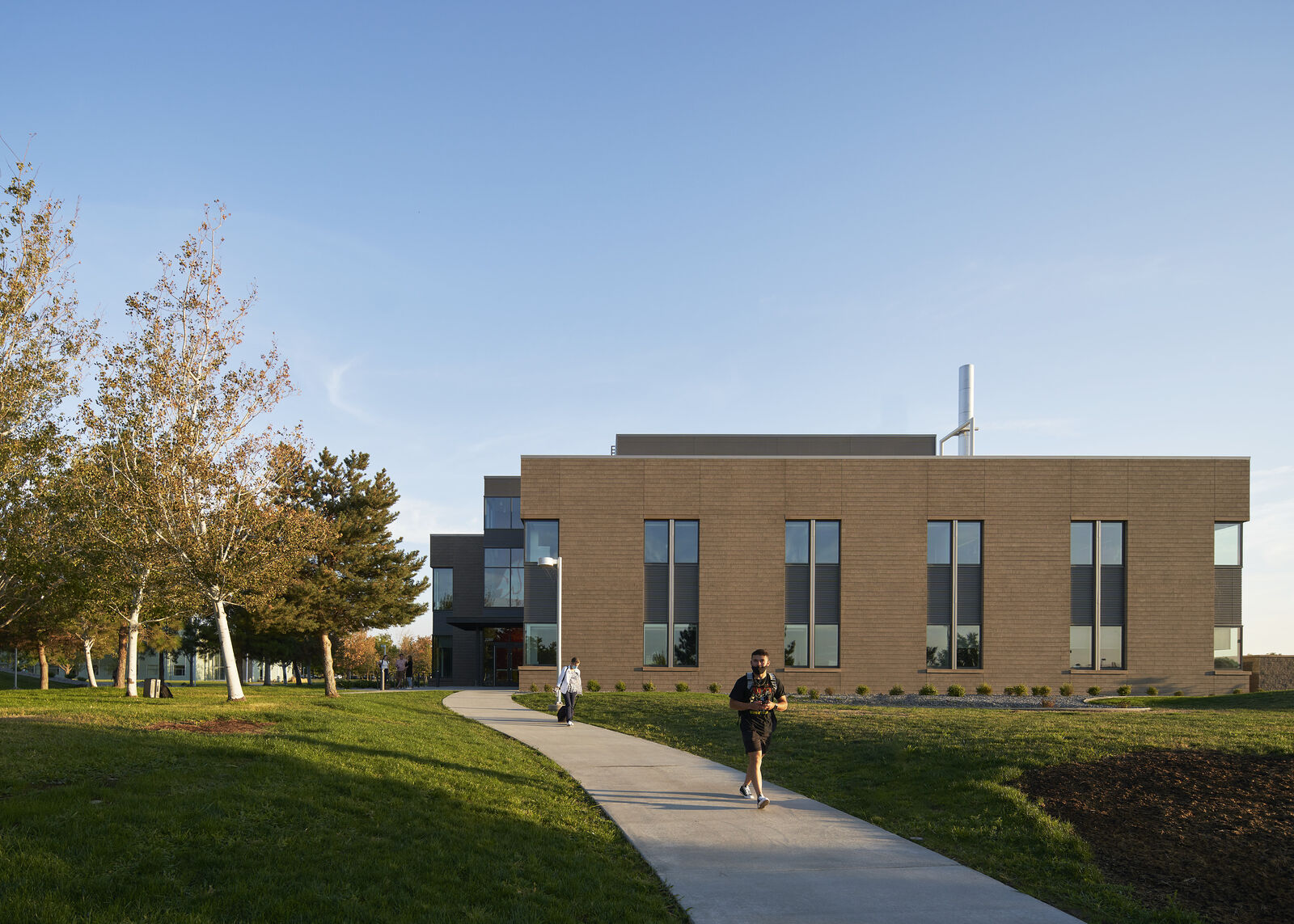 exterior view of the side of the building with student walking down pathway 