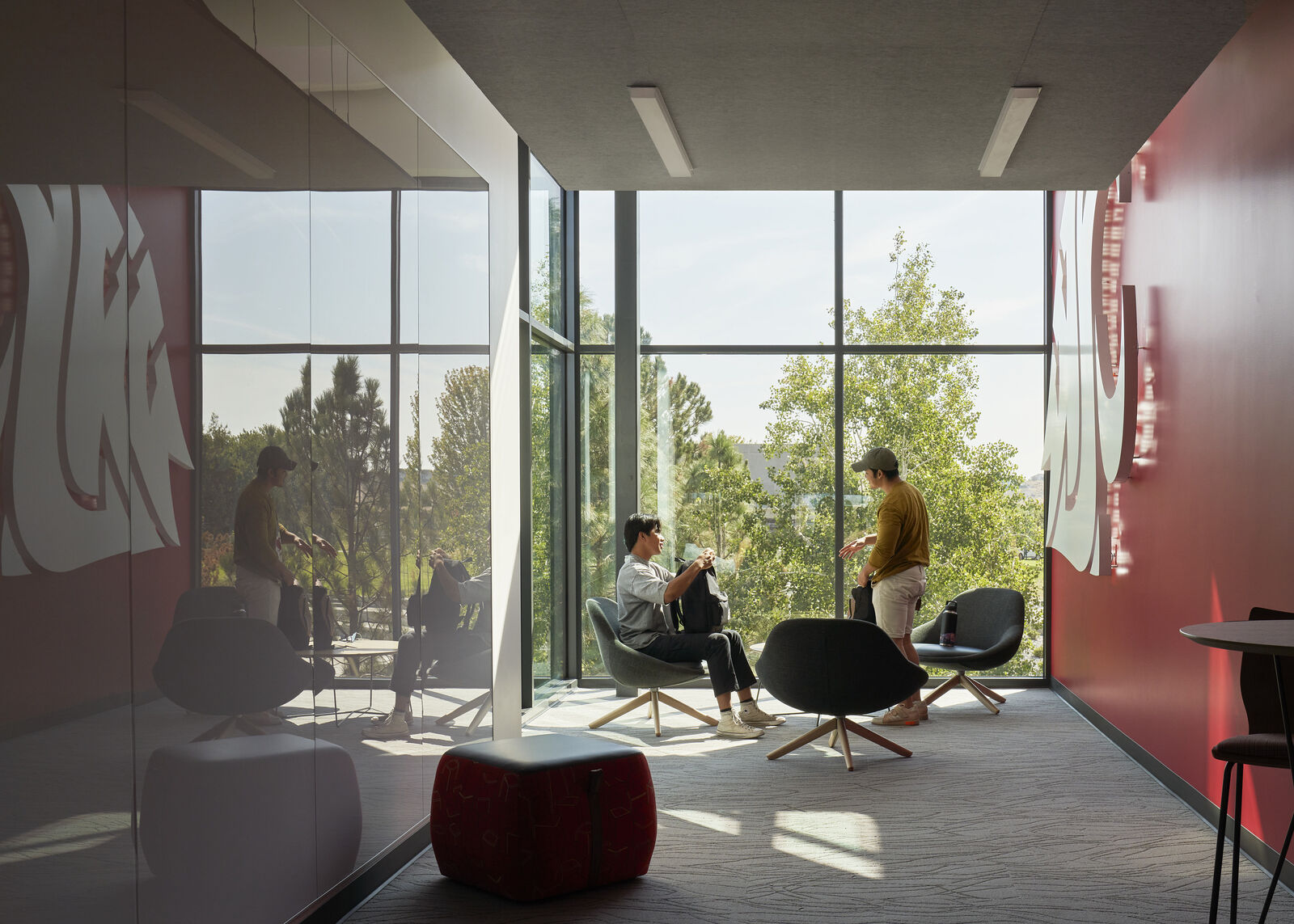 Two students talking to one another in brightly lit room 