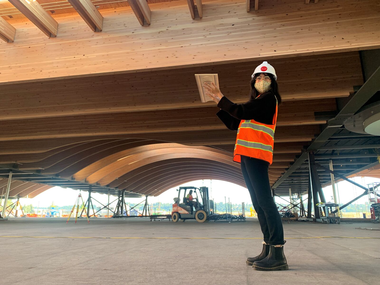 Woman holding small model under the roof of the real wooden roof of the Portland International Airport New Main Terminal. 
